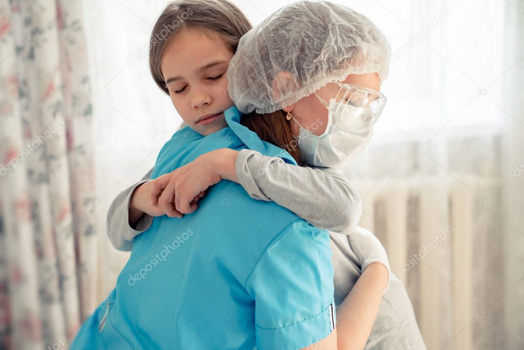 mom Doctor in mask examines kid at home and hugs.