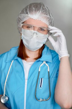 Koruyucu mavi üniformalı doktor, tıbbi maske..