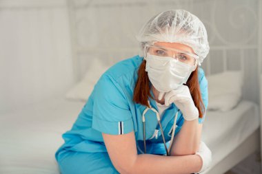 Kadın doktor oturuyor ve yorgun.