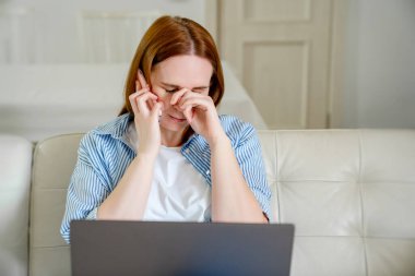 Kanepede telefonla konuşan ağlayan kadın.