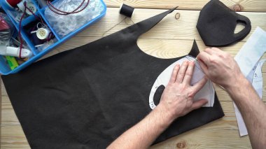 Erkek eli makasla desen maskesi çizer.