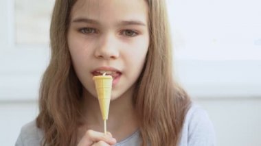 Tenn kız kremalı waffle bardağında şeker yiyor..
