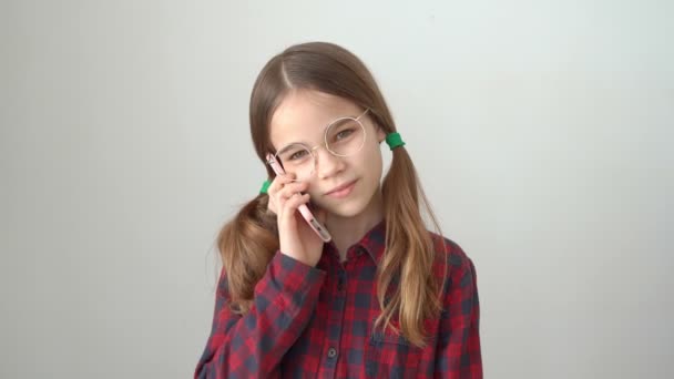 Jolie fille parler par téléphone mobile près mur blanc — Video