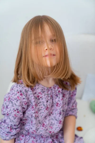 Portrait petite fille blonde dans une robe violette . — Photo