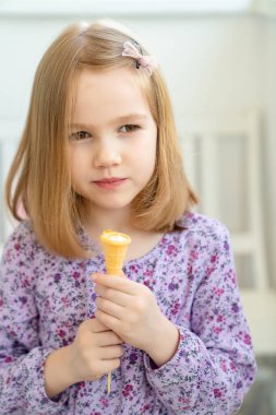 Küçük kız kremalı waffle bardağında şeker yiyor.. 