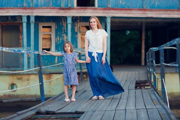 Mamá y el niño en ropa azul de pie puente viejo — Foto de Stock