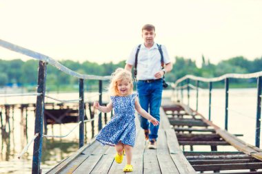 Mavi elbiseli çocuk ve baba eski köprüye gidiyorlar.