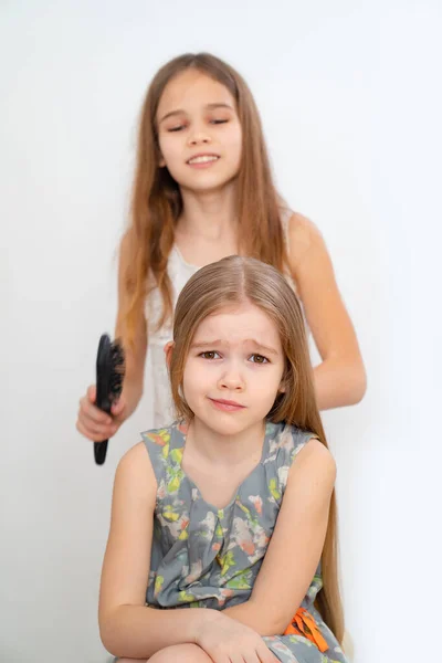 Kleines Mädchen beim Haareputzen ihrer jüngeren Schwester — Stockfoto