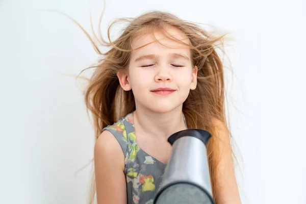 Petite fille séchant ses cheveux longs avec sèche-cheveux — Photo
