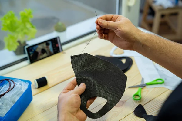 Manos de hombre coser con una máscara de aguja negro —  Fotos de Stock