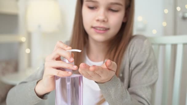 Adolescente usa desinfetante para limpar as mãos . — Vídeo de Stock