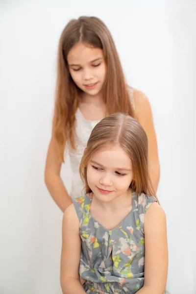 Pequeña niña cepillando el pelo de su hermana menor —  Fotos de Stock