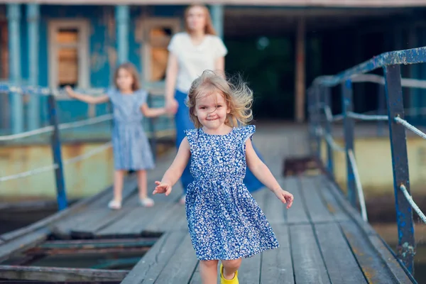 Mamma och barn i blå kläder stående gammal bro — Stockfoto