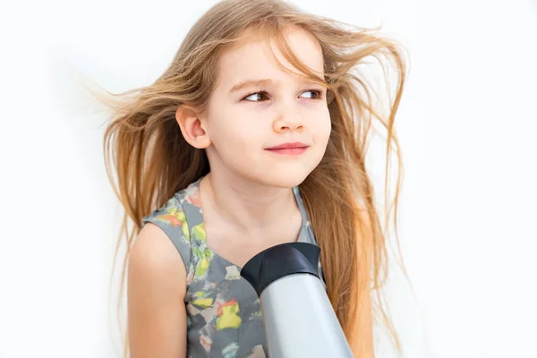 Mała dziewczynka suszenie jej długie włosy z suszarką do włosów — Zdjęcie stockowe