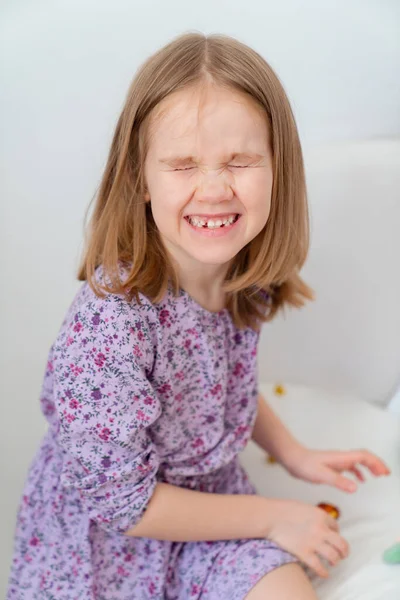 Portret klein meisje blond in een paarse jurk. — Stockfoto