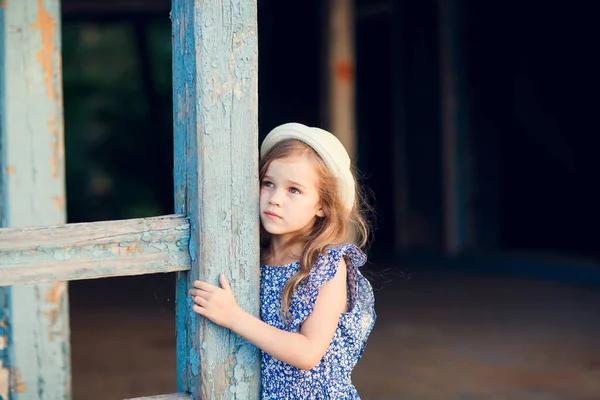 Niña de pie en el porche de la vieja casa en ruinas . —  Fotos de Stock