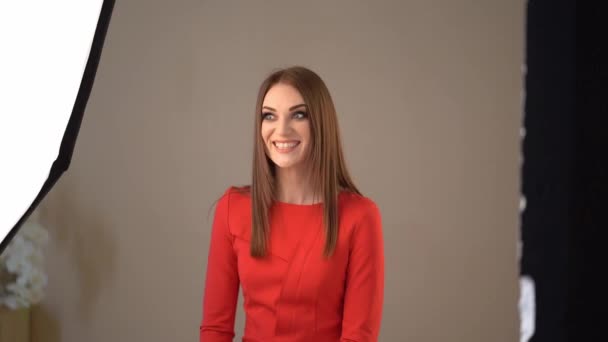 En sesiones de fotos entre bastidores de Studio. chica en rojo . — Vídeos de Stock