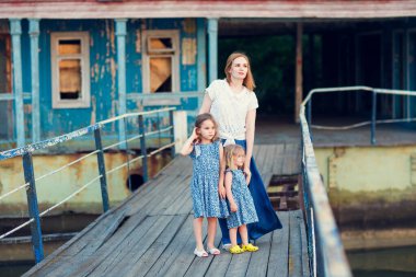 Annem ve mavi elbiseli çocuklar eski köprüde duruyorlar.