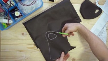 Erkek elleri makasla desen maskesini keser.