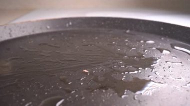 Ağır çekim. Bir sosis sıcak tavaya düşer.