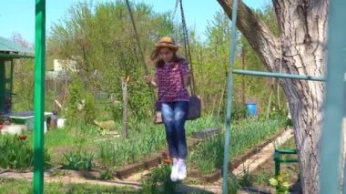 Şapkalı kız köyde sallanıyor.