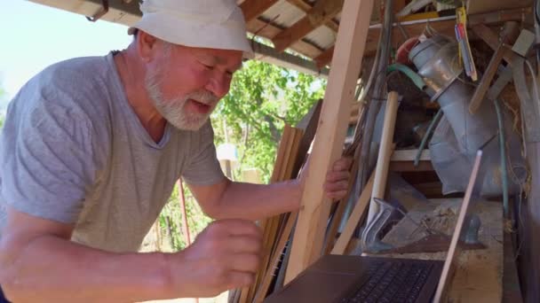 Elderly man communicates with a laptop in village