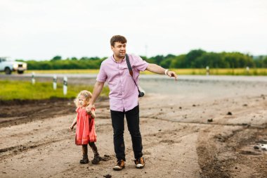 Baba ve çocuk yağmurdan sonra kirli yollara düşerler..