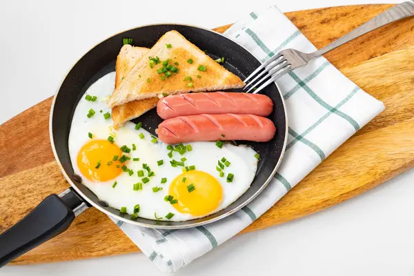 Πρωινό. λουκάνικα, αυγά και ψωμί σε τηγάνι. — Φωτογραφία Αρχείου