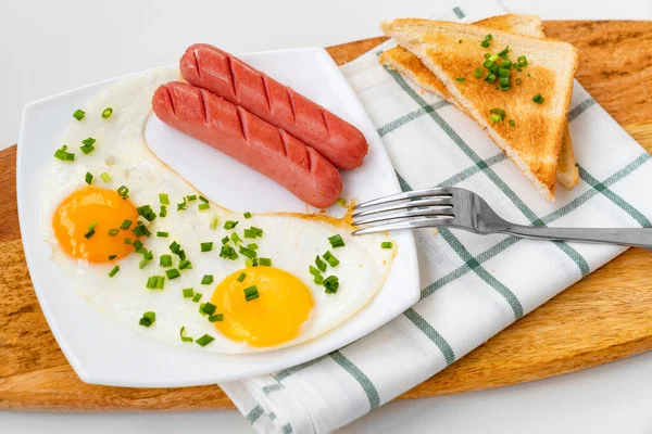 Πρωινό. λουκάνικα, αυγά και ψωμί στο πιάτο — Φωτογραφία Αρχείου