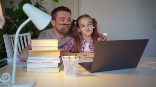 Dad plays and helps daughter lessons on laptop — Stock Video