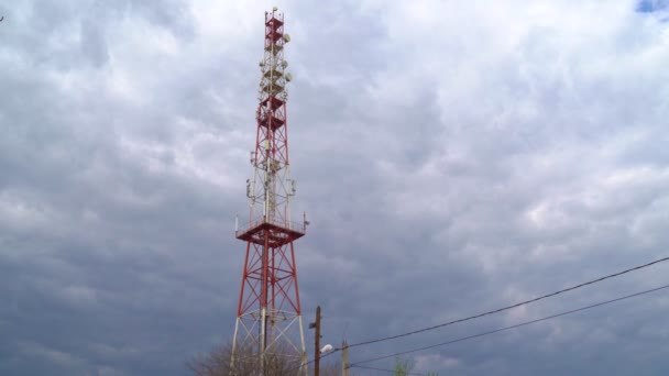 Телекоммуникационная башня на фоне облачного неба — стоковое видео