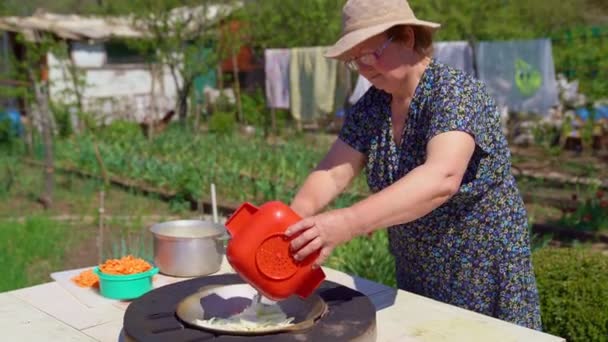 Kobieta smażyć cebulę w garbarni w ogrodzie. — Wideo stockowe