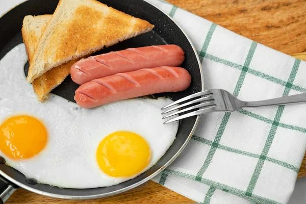 Сніданок. ковбаски, яйце і хліб у сковороді . — стокове фото