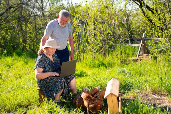 Anciano hombre y mujer con un portátil en la aldea — Foto de Stock