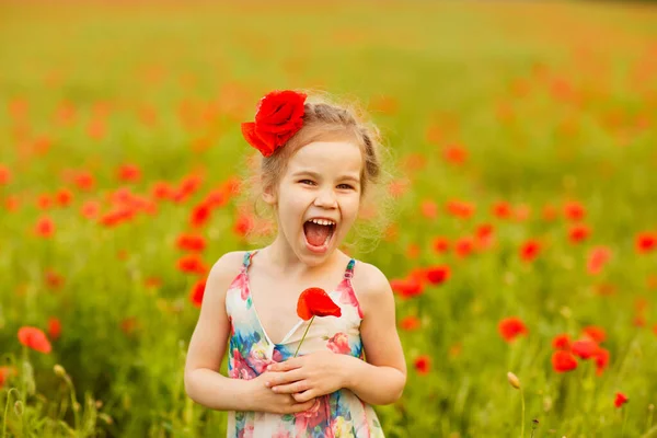 Bela criança colhendo flores no campo de papoula — Fotografia de Stock