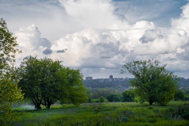 Gökyüzü üstüne yağmur, büyük bulutlar. Şehir silüeti.