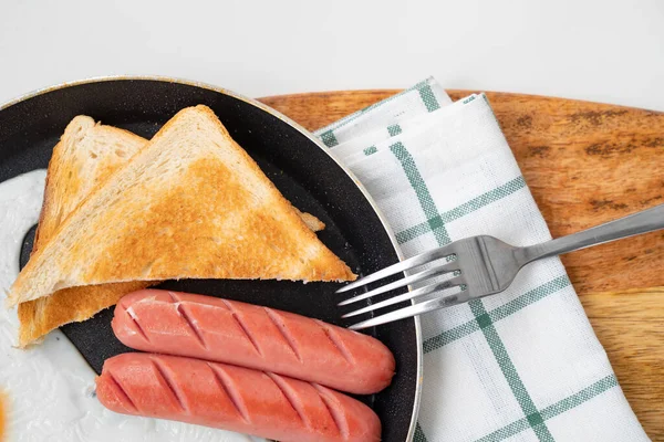 Frukost. Korv, ägg och bröd i skillet. — Stockfoto