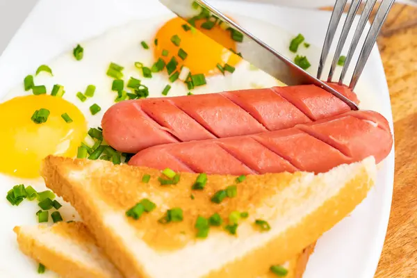 Kniv skär bit korv. Engelsk frukost — Stockfoto