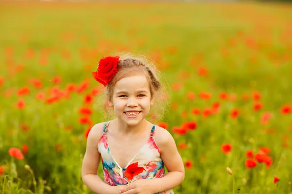 양귀비 들판에서 꽃송이를 따는 아름다운 어린이 — 스톡 사진
