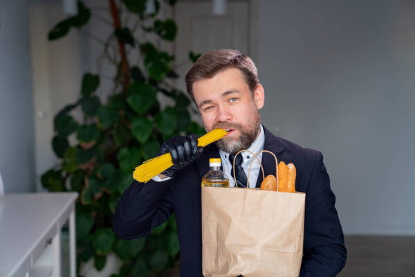 Businessman in black gloves eats raw spaghetti