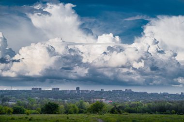 Gökyüzü üstüne yağmur, büyük bulutlar. Şehir silüeti.
