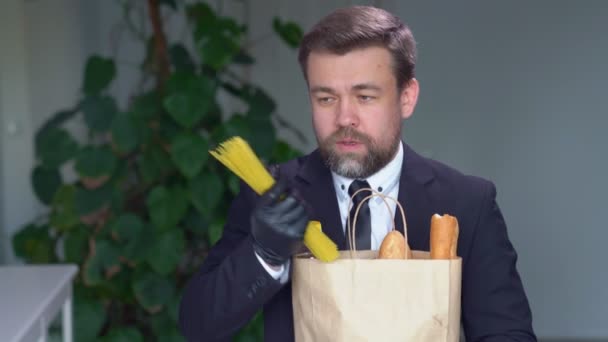 Biznesmen w czarnych rękawiczkach je surowe spaghetti — Wideo stockowe