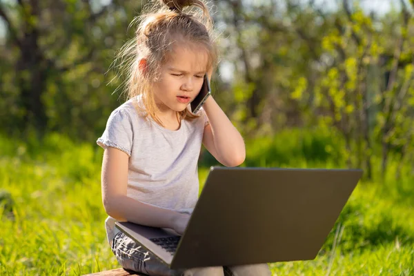 Niña hablar por teléfono, con ordenador portátil en la aldea — Foto de Stock