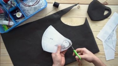 Erkek elleri makasla desen maskesini keser.