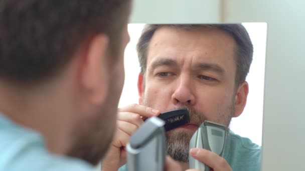 El hombre hace corte de pelo de afeitar la barba en casa . — Vídeos de Stock