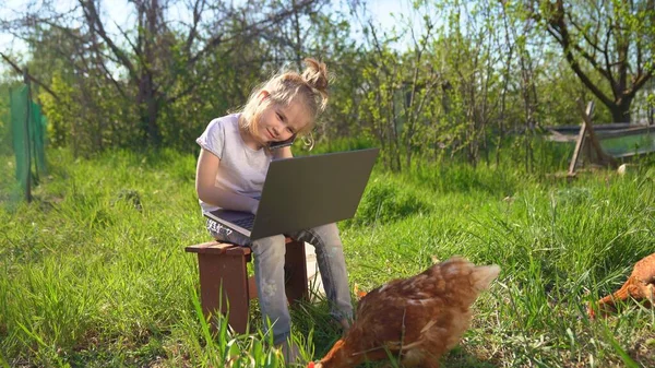 Kleines Mädchen telefoniert mit Laptop im Dorf — Stockfoto