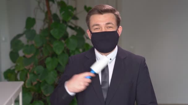 Homem de negócios em máscara limpa roupas de rolo pegajoso — Vídeo de Stock
