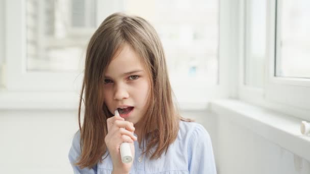 Chica somnolienta limpia los dientes cepillo de dientes eléctrico — Vídeo de stock