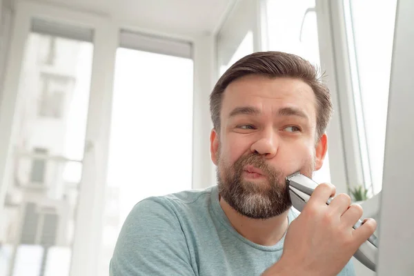 男は家で髭剃りの髪型を作る. — ストック写真