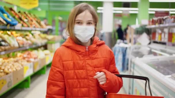 Menina em máscara médica escolhe produtos na loja — Vídeo de Stock